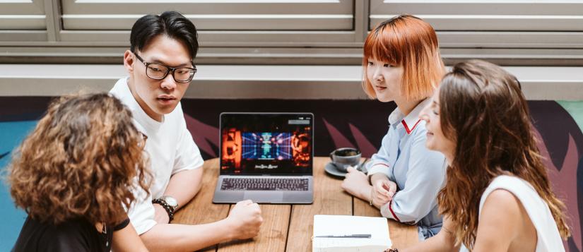 Collaborating around a laptop at a cafe table