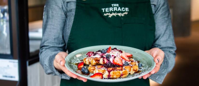 Plate of fruit crepes, apron reads The Terrace