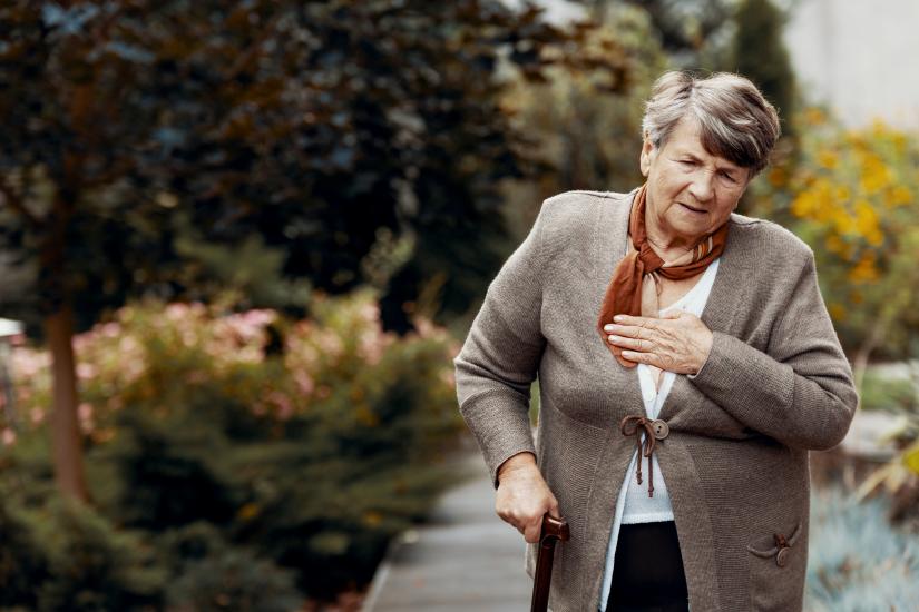 Weak senior woman with walking stick struggling to breathe