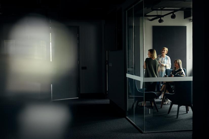 Group of postgrad students interacting in a dark-lit room