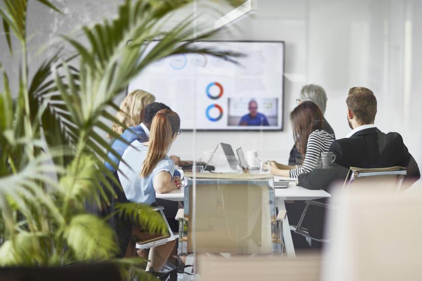 People around a desk having a business meeting