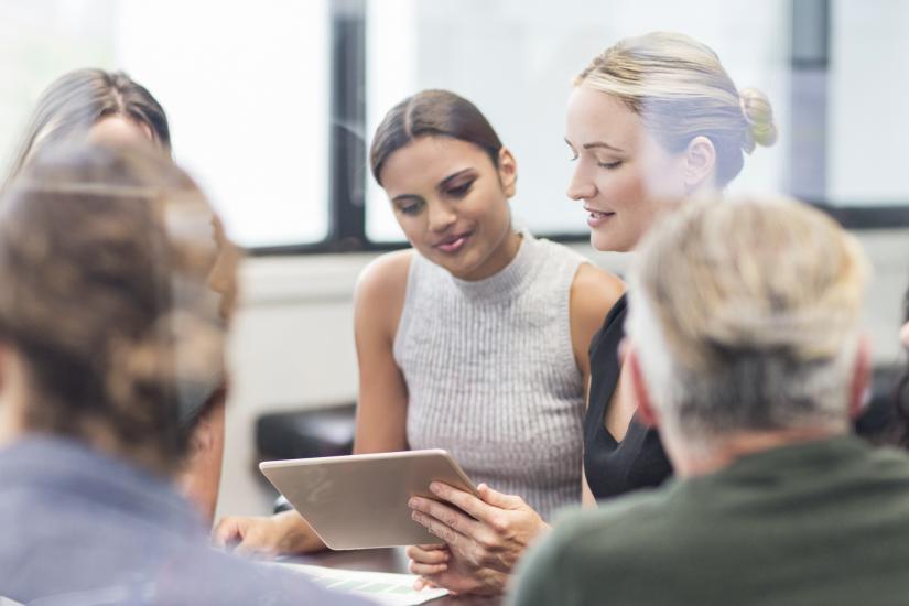 Women looking at a digital tablet on a meeting