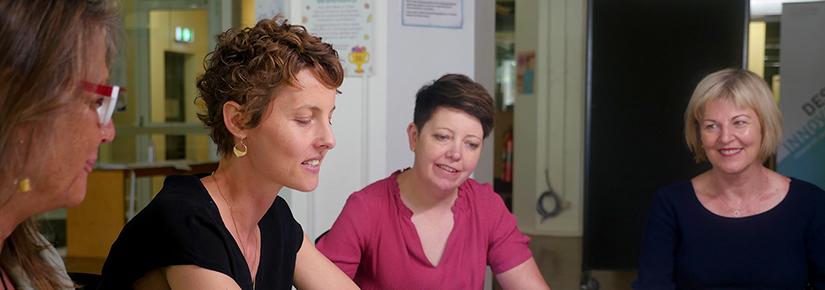 Smiling colleagues working together around table with coloured post-it notes