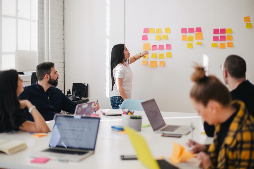 Woman brainstorming in front of team