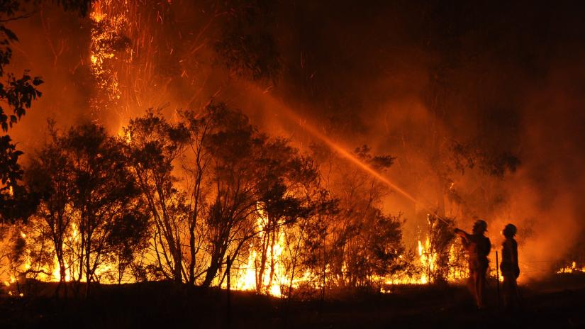 firefighters in silouette against flames