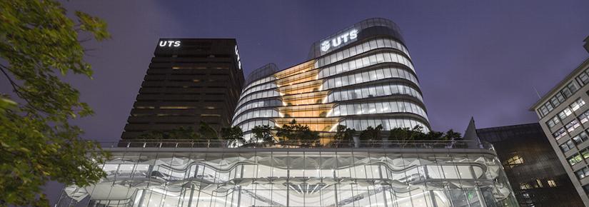 Illuminated UTS Central building with Tower in background, night