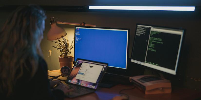 Young woman using a computer with a number of screens open