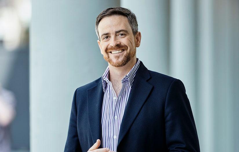 Man in a suit smiling and looking at the camera