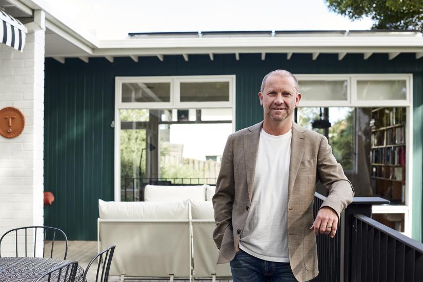 Anthony Burke in front of a restored house