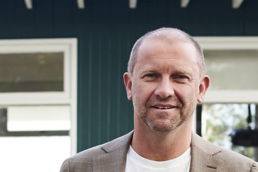 Anthony Burke in front of a restored house