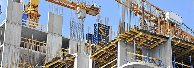 Crane and building construction site against blue sky