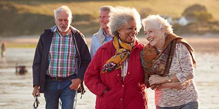 Elderly group of friends walking along beach