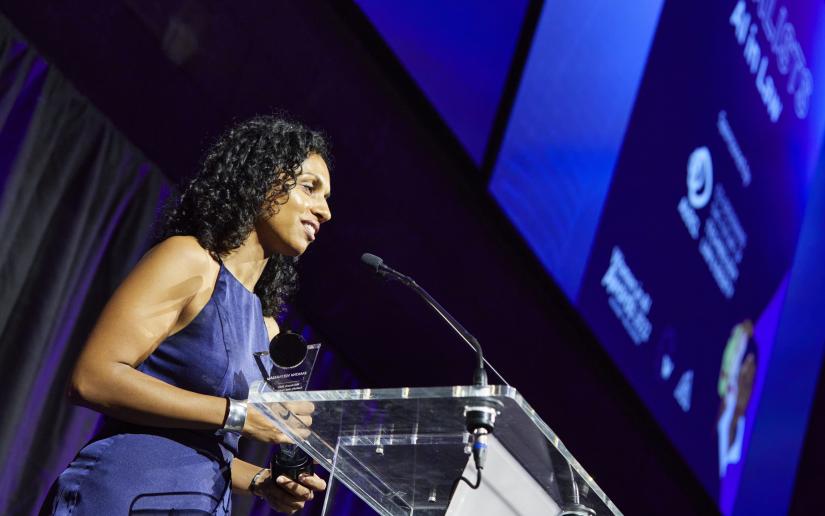 Dr Ramona Vijeyarasa accepts her Women in AI award at a ceremony in Melbourne in 2022