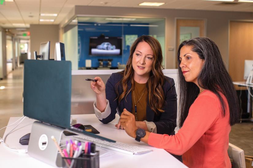 Two woman at work in front of a computer