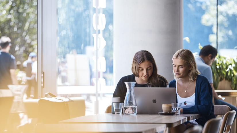 Two UTS students collaborating in a cafe on campus