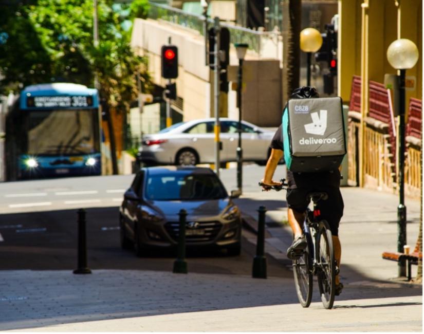 Food delivery bike going down hill, sunny day