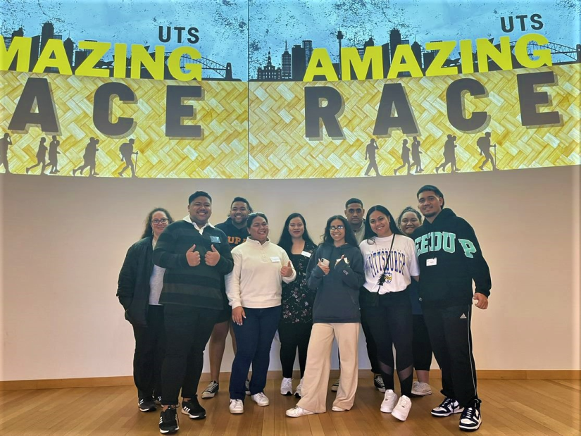 Students standing infront of Amazing Race Banner