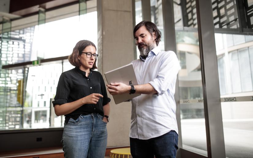 Two UTS researchers look at a computer screen.