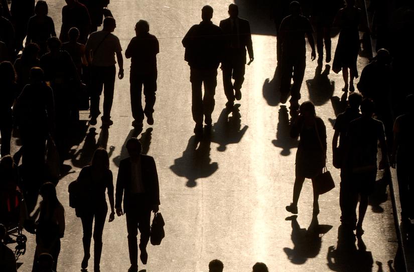 view from above of people walking silhouetted against golden street background rome