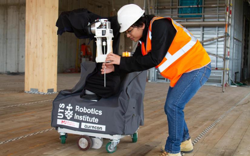 UTS researcher Dinh Dang Khoa Le fits a screw into QUENDA-BOT's arm while trialling the technology on a construction site. Photo supplied by Murdoch University.