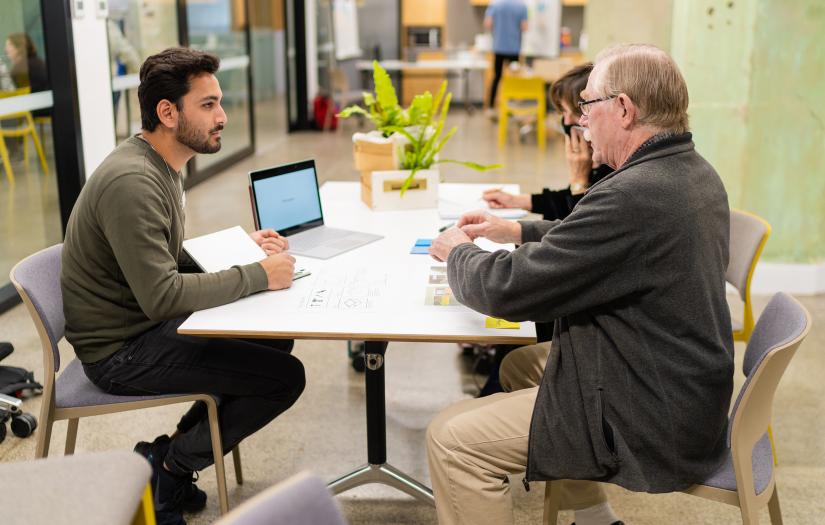 Student working with two older people