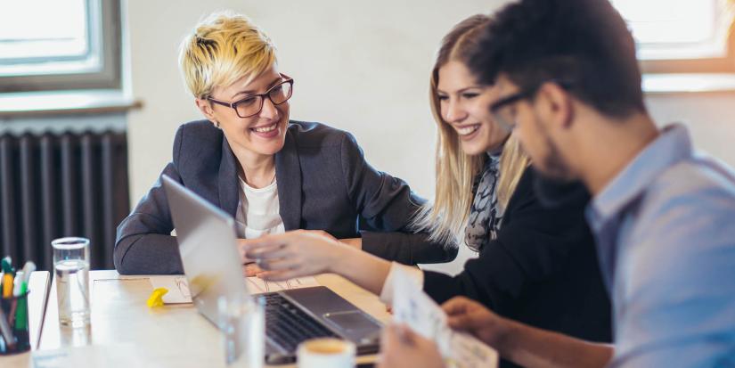 Three people looking at laptop