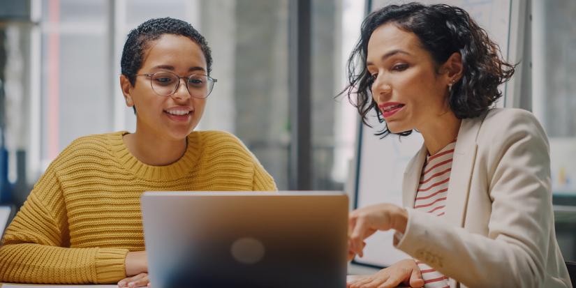 Two women have a discussion in a meeting room