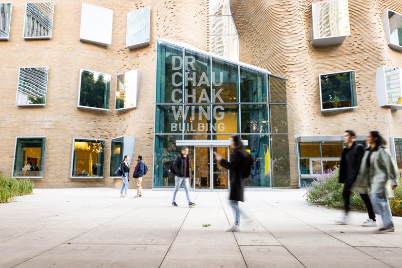 Photograph of Building 8 exterior as 6 students walk by