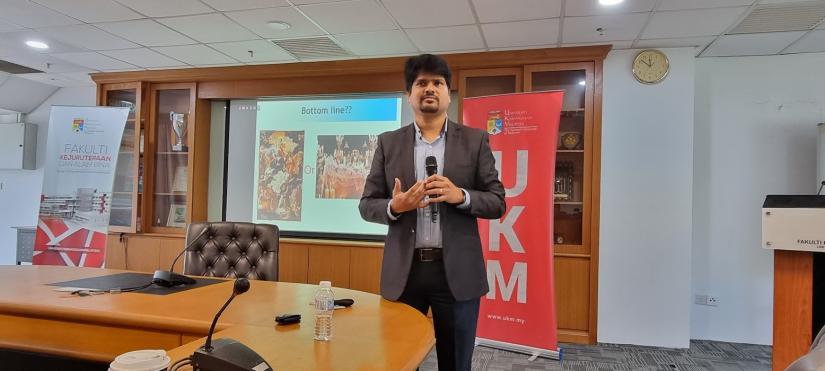 Image of Professor Biswajeet Pradhan presenting to a group of people who are behind the camera