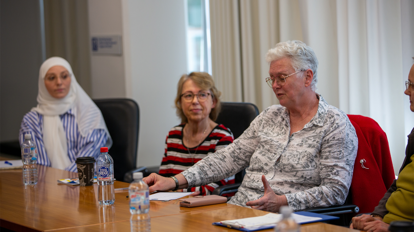 four women sitting at board room table for consumer meeting