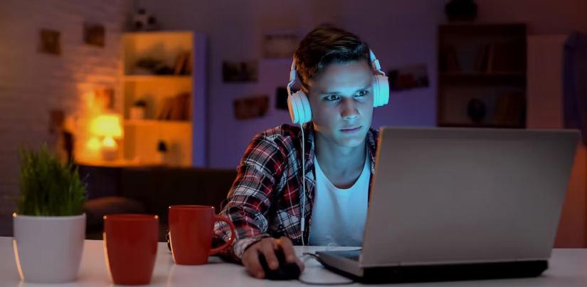 a young person stares at a computer screen