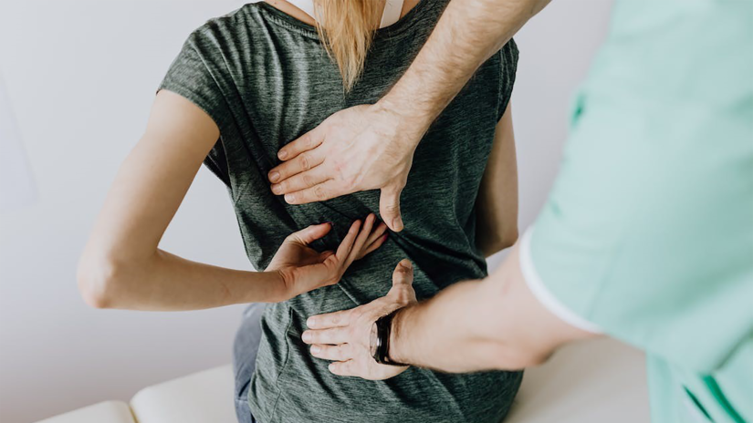 Clinician examining patient for back pain