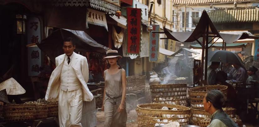 A man and woman walk through a street