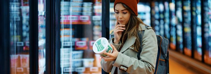 Woman checks food labels in the supermarket.