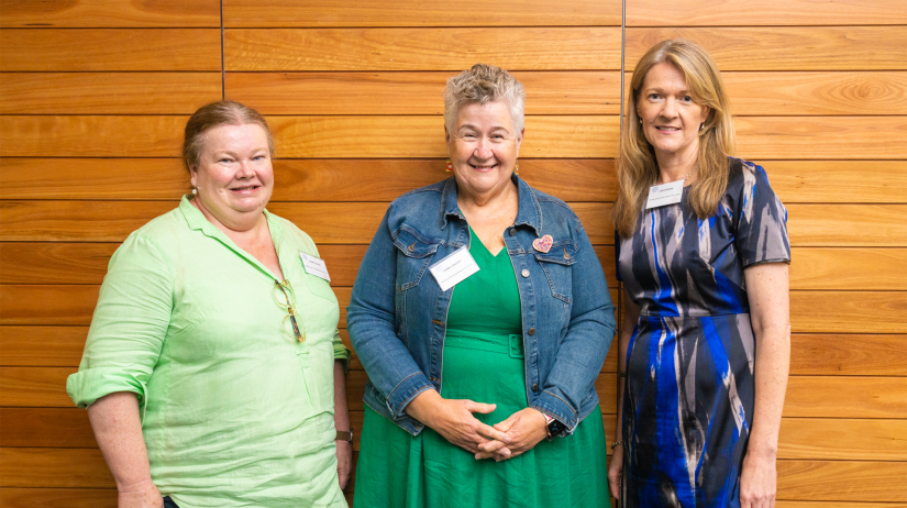 Joanne Cooper, Fiona Lysaught and Linda Brown staning in front of wood-panelled wall. 