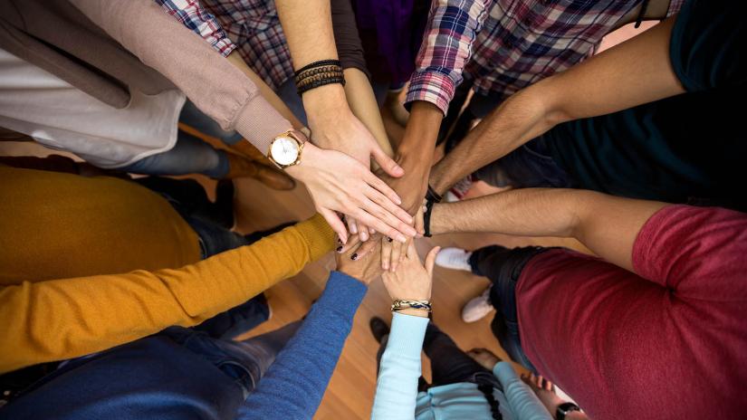 People with joined hands as a team