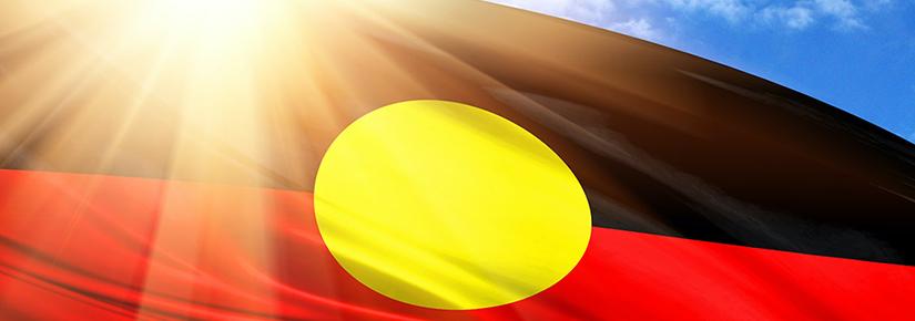 Stock picture of the Aboriginal flag against a sunny sky