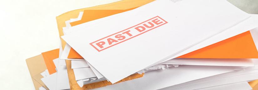 Stock picture of a pile of mail with an overdue notice on the top