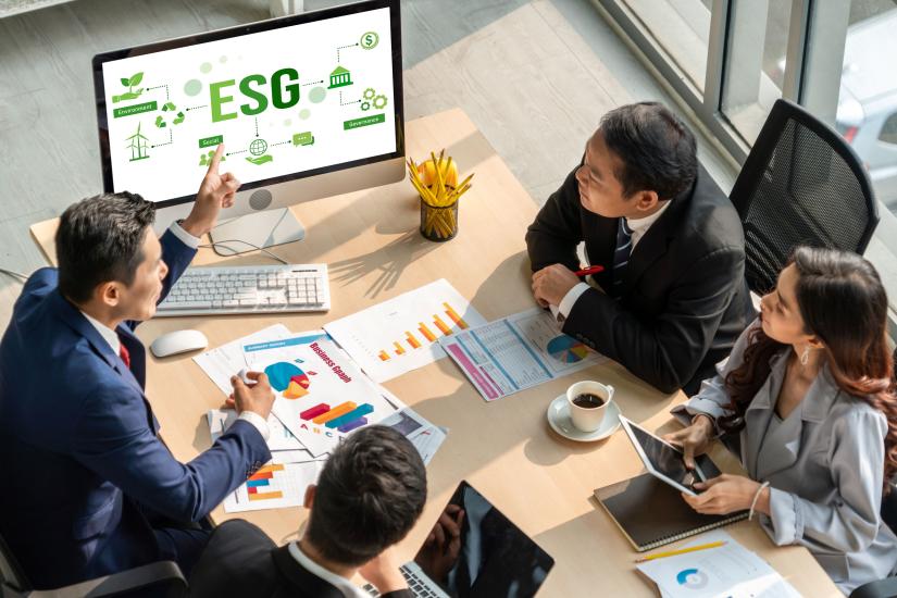 Table with computer screen and people in a meeting