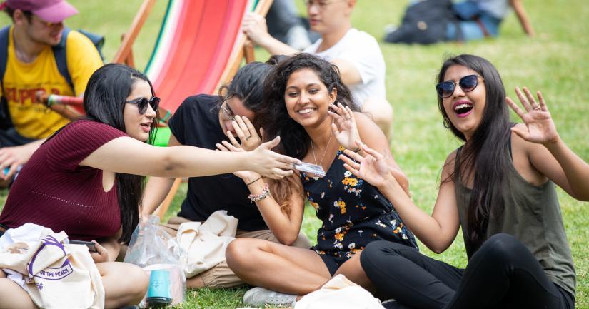 A group of university students sitting and smiling together.