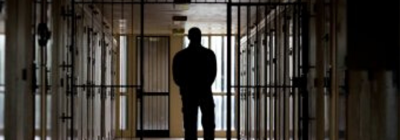 Man walking through prison corridor