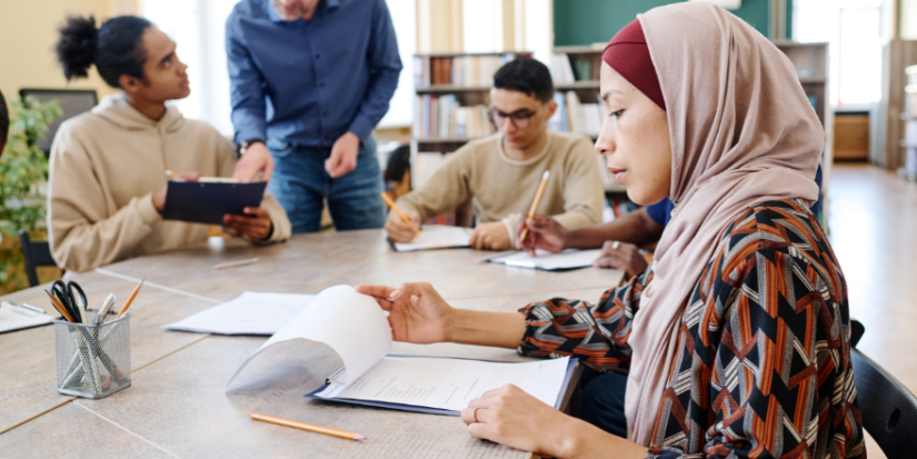 Image of a woman in a headscarf filling in a form