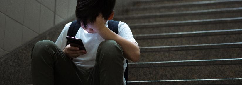 Boy looks at his mobile phone