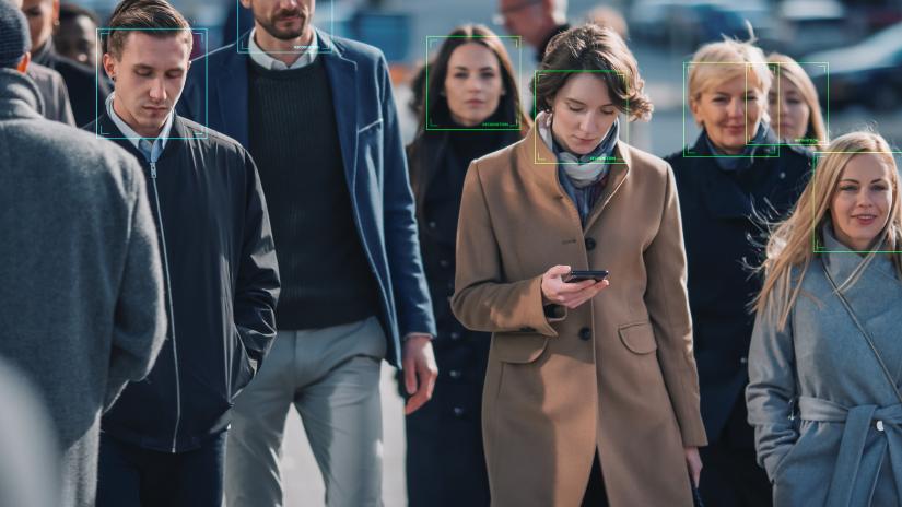 a crowd walking, facial recognition boxes superimposed on faces