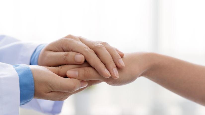 A doctor holding hands with a patient