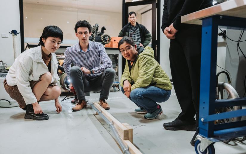 UTS robotics students observe a 'soft robot' grow and navigate a tube during a demonstration for NBN representatives.