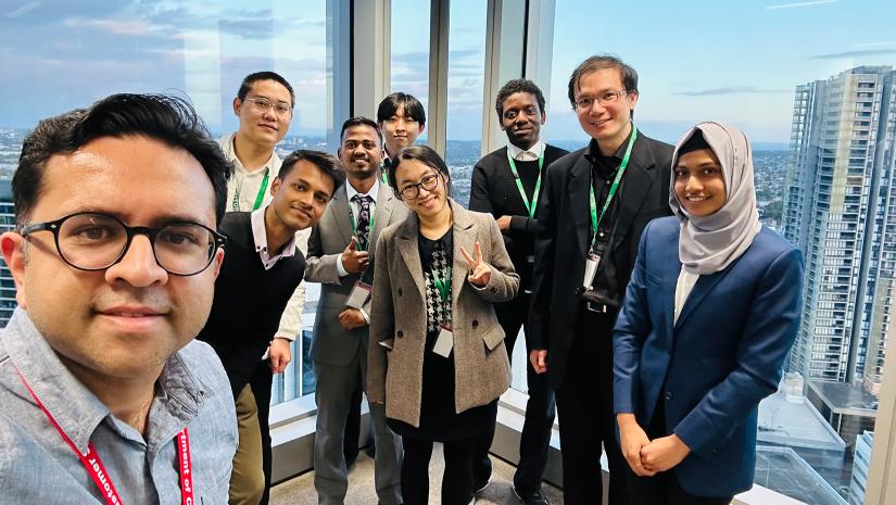 Nine students smiling for group photo with intern supervisor