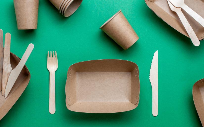 a stock photo of compostable packaging food containers, including a fork and a knife.