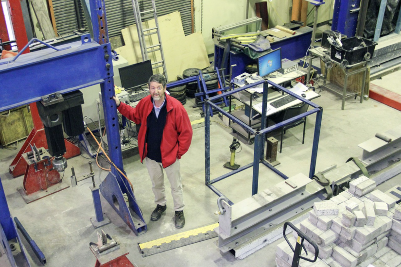 A man standing in a workshop, looking up at the camera