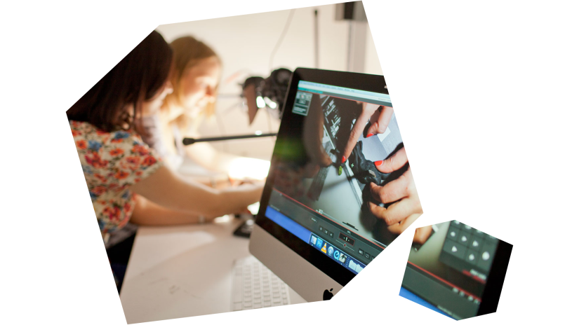 Two students work on a project on a Mac computer